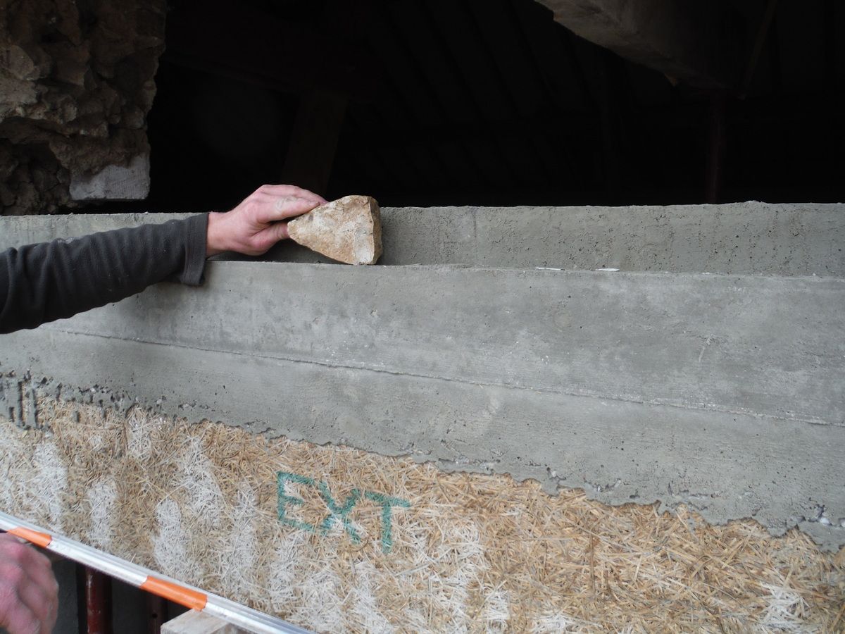 On remonte le mur en pierre au dessus du linteau en béton