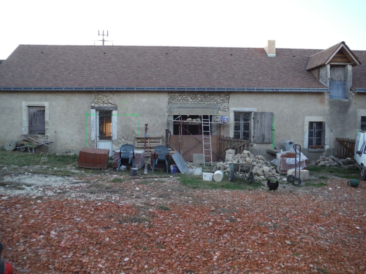 On remonte le mur en pierre au dessus du linteau en béton