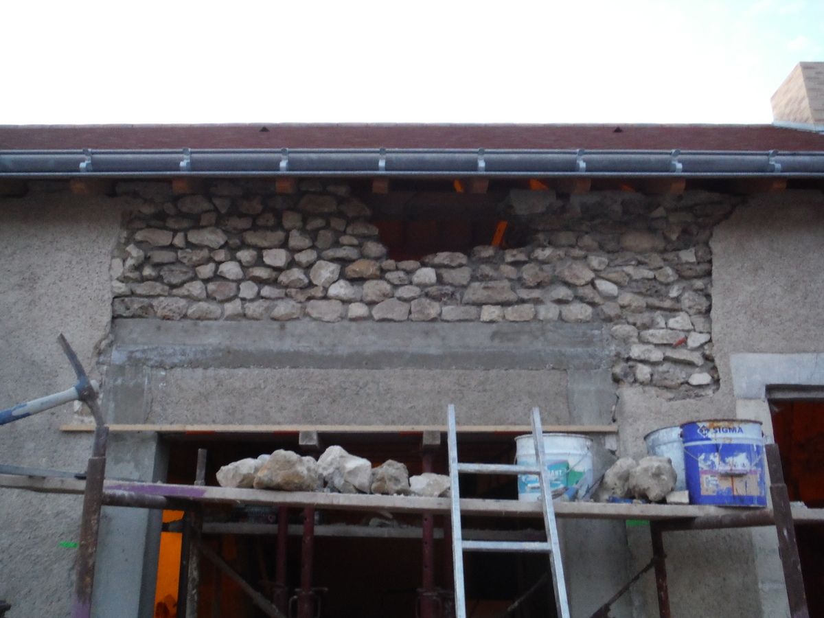 On remonte le mur en pierre au dessus du linteau en béton